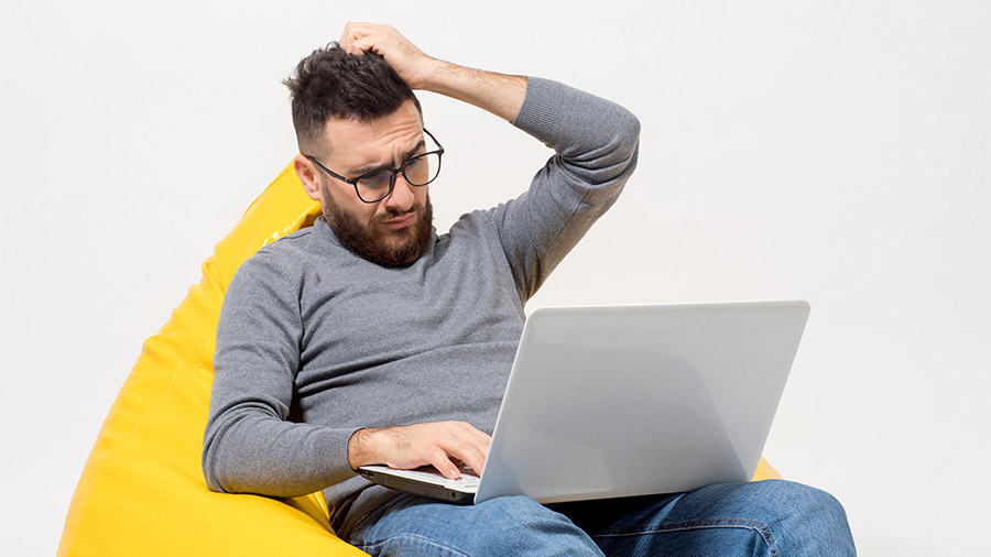 Joven en computadora preocupado