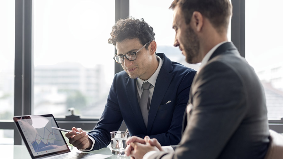 Hombres de negocios en junta hablando sobre política de calidad para ISO 9001