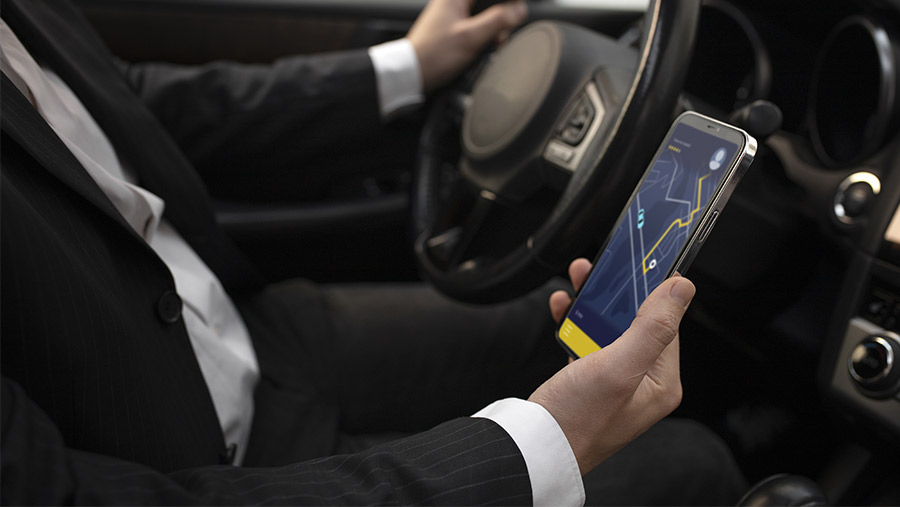 Hombre manejando con smartphone mientras usa GPS