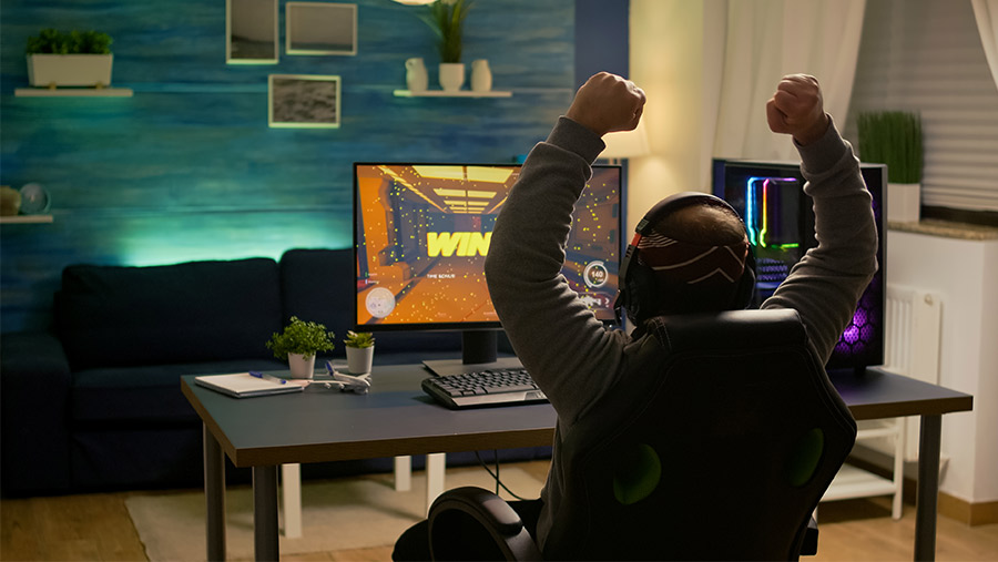 Hombre jugando videojuegos frente a computadora