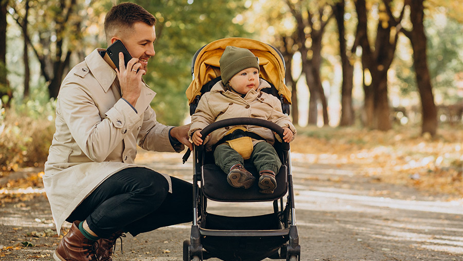 Hombre con celular y paseando con bebé