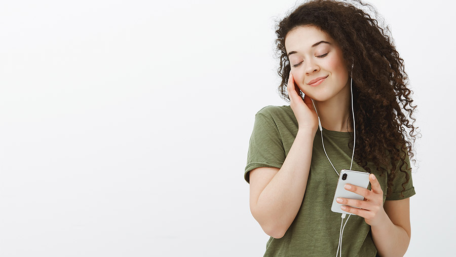 Joven escuchando música con audífonos en su smartphone