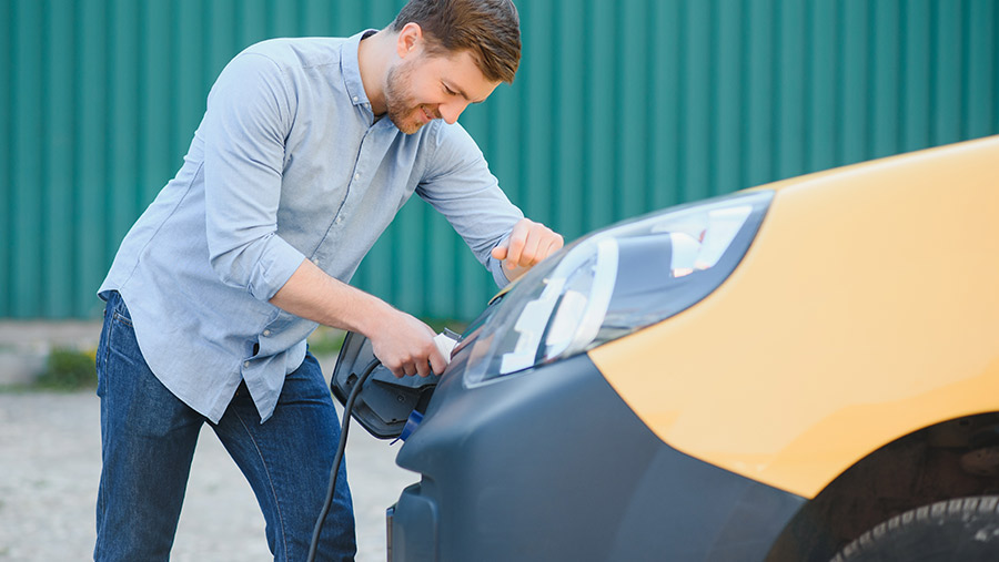 Hombre cargando auto eléctrico