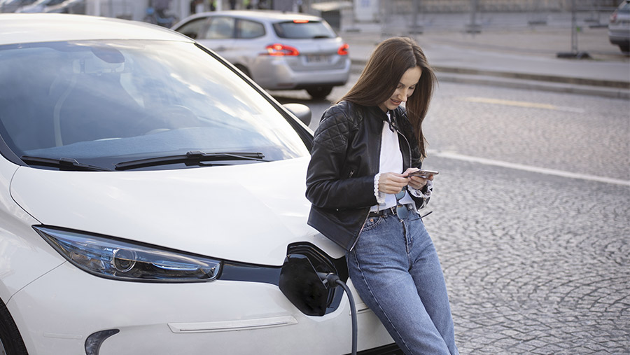 Mujer cargando auto eléctrico