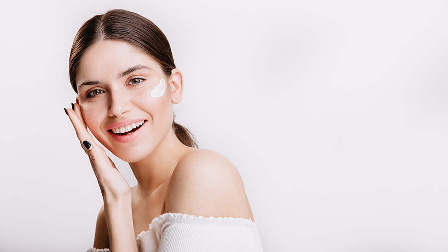 Mujer usando crema hidratante aplicando consejos para cuidar la piel