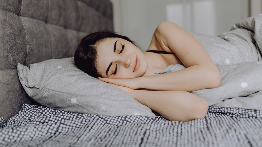 Mujer descansando tras conocer los mejores tejidos para dormir