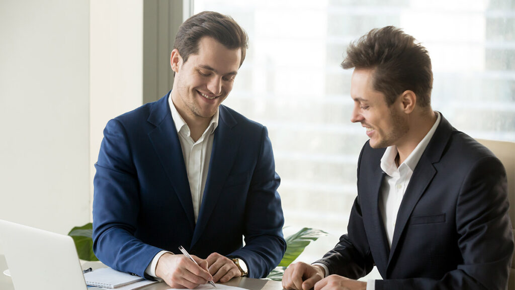 Hombres empresarios de traje firmando papeles