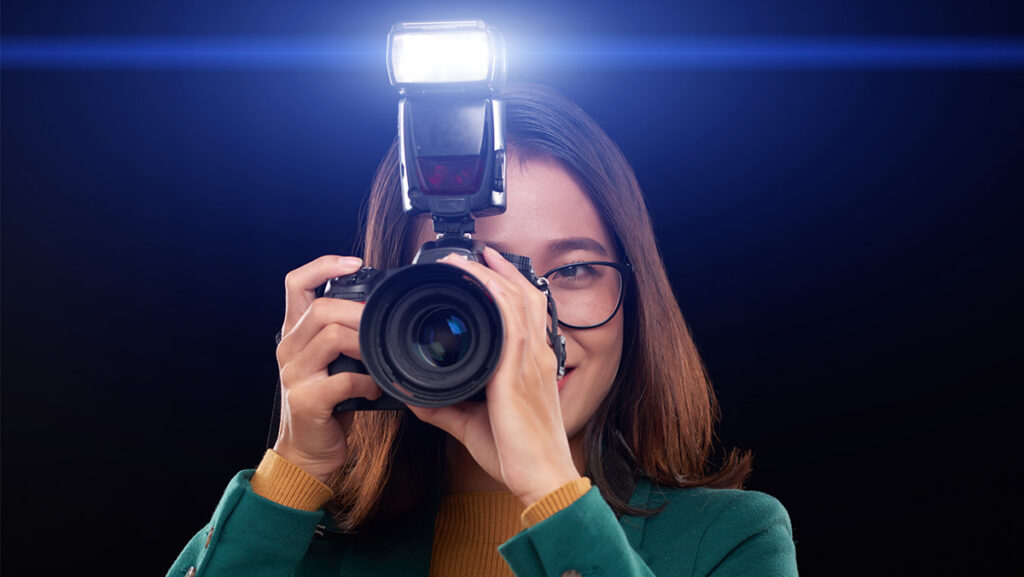Mujer con lentes tomando una fotografía con flash
