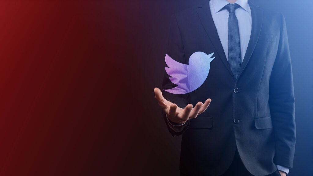 Hombre de traje sosteniendo logo de Twitter