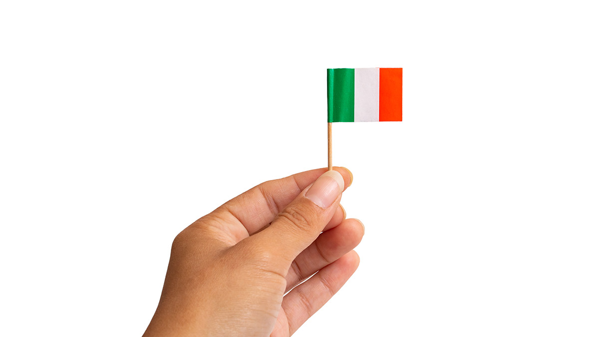 Mano sosteniendo pequeña bandera de Italia
