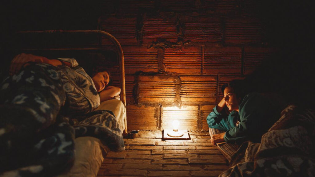 Mujeres acostadas en sus camas y colchoneta conversando