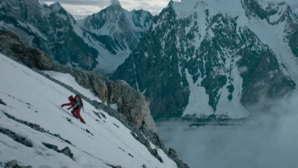 Alpinista wspina się na dużą górę lodową