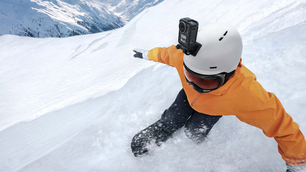 Hombre practicando deporte extremo en nieve con cámara de acción en el casco