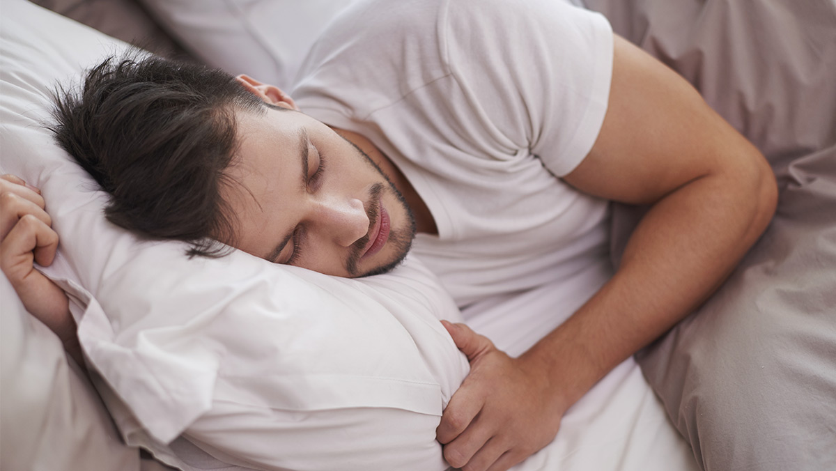 Hombre con pijama blanca durmiendo
