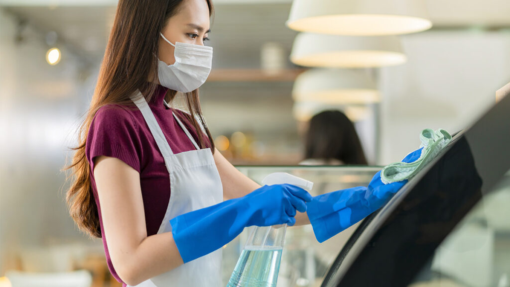 Mujer asiática limpiando con pulverizador