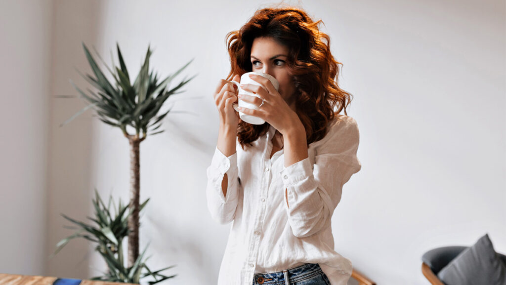 Mujer tomando taza de café en la mañana