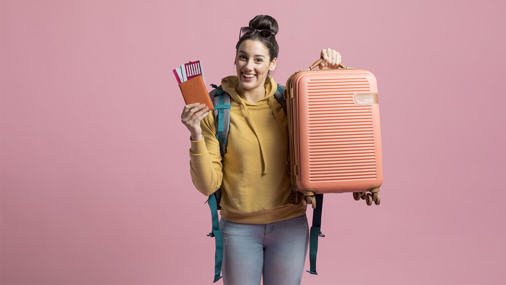 Mujer joven con maleta y boletos de avión en pasaporte
