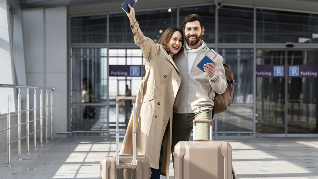 Pareja en el aeropuerto con maletas listas