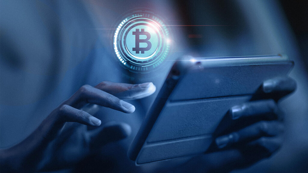 Símbolo de bitcoin y una persona enviando criptomonedas por smartphone