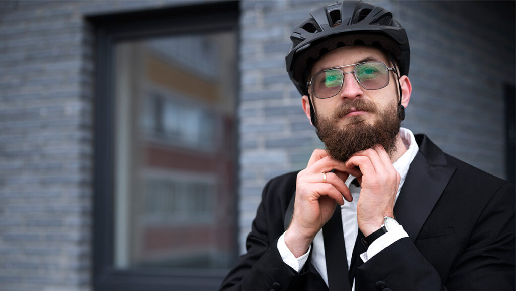 Hombre den traje con casco para bicicleta