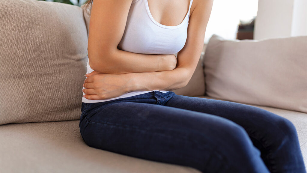 Mujer con molestia presionando el abdomen