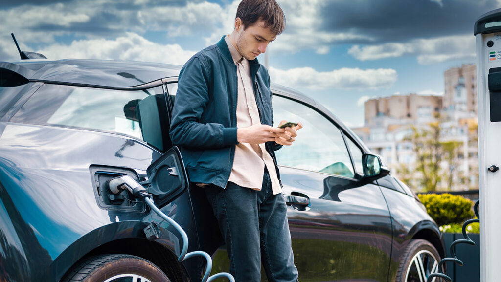 Joven cargando su auto eléctrico