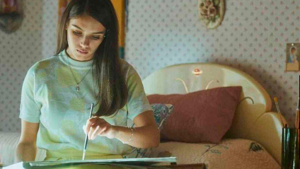 Joven actriz pintando sobre un cuaderno en serie de Netflix