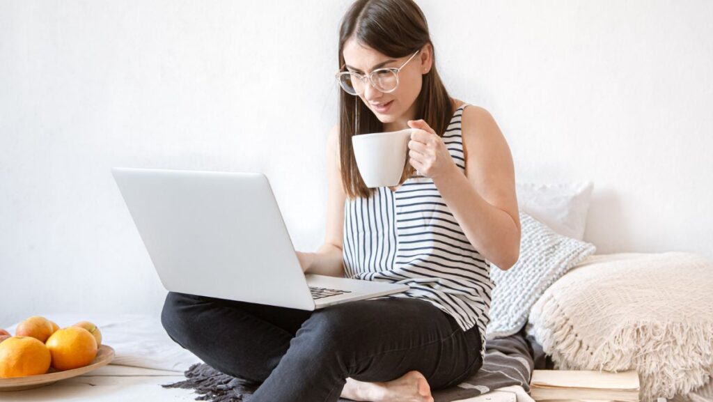 Mujer trabajando en computadora con taza de café