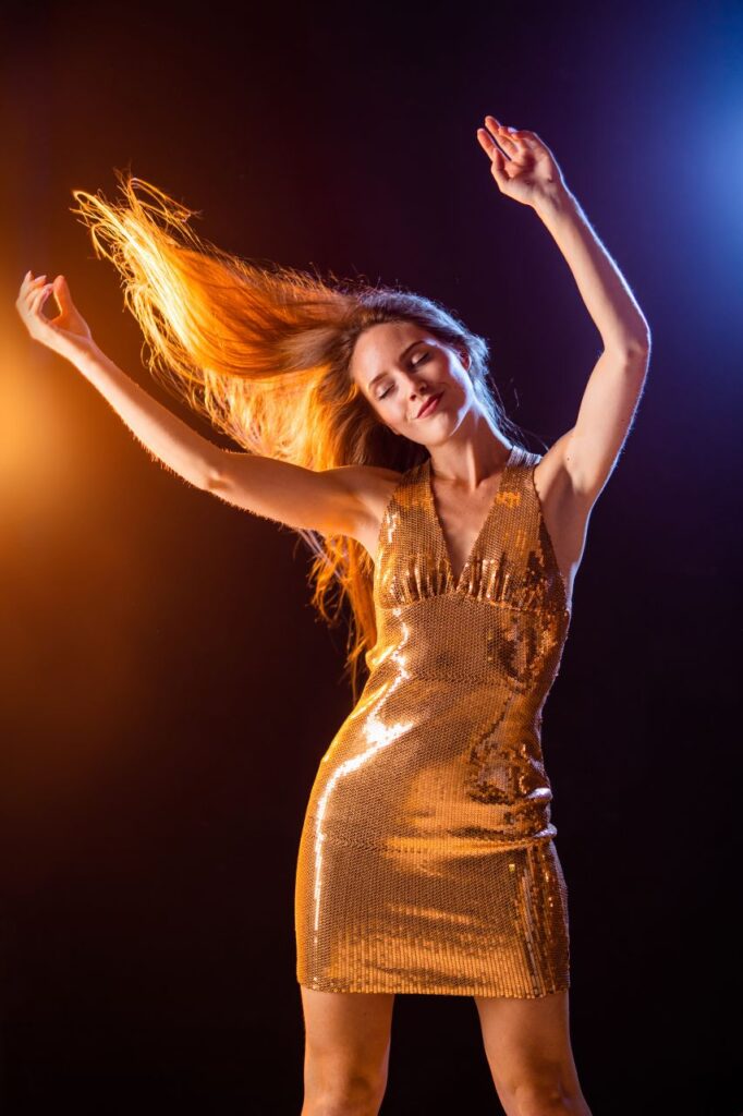 Mujer bailando con vestido dorado