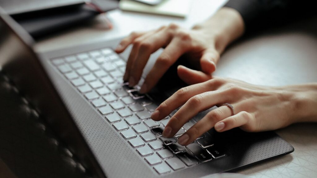 Mujer escribiendo en una computadora