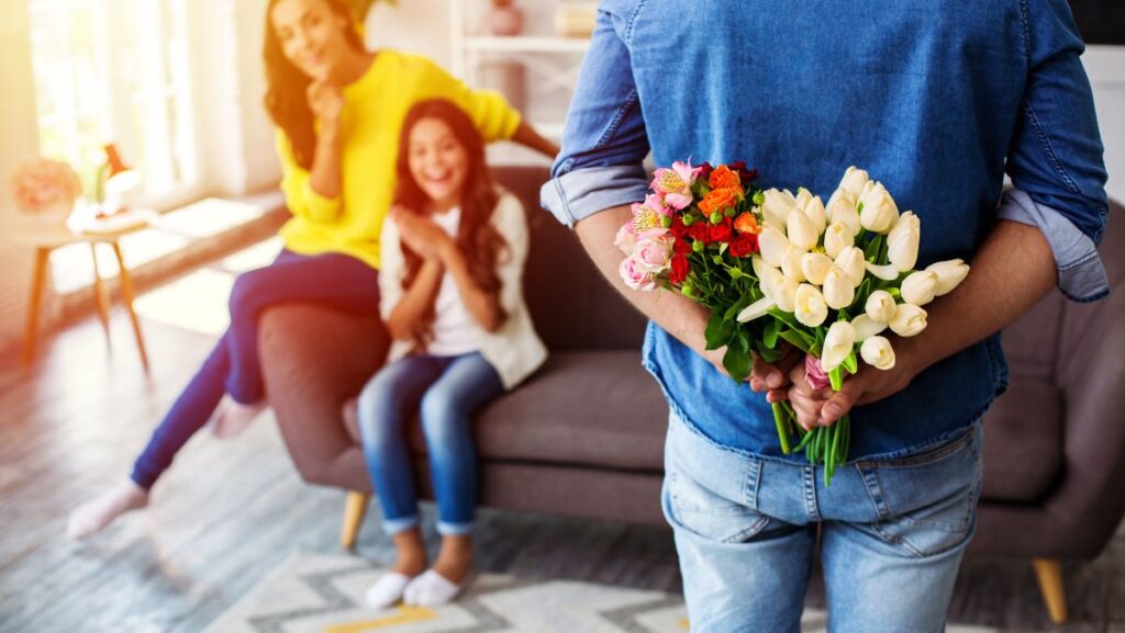 Hombre regalando flores a hija y esposa