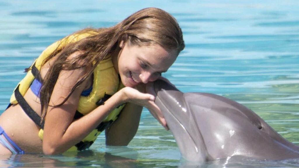 Mujer nadando con delfines en Dolphinaris