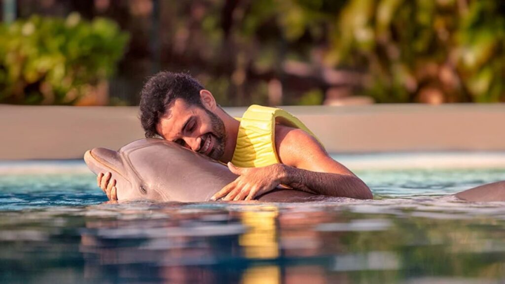 Hombre nadando con delfines en Dolphinaris