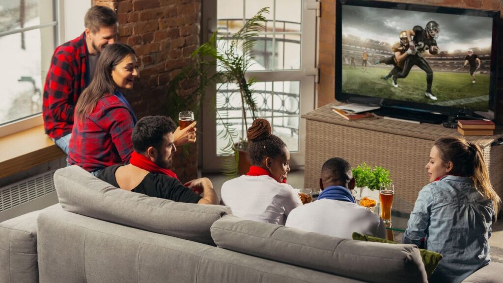 Grupo de amigos viendo fútbol americano en TV