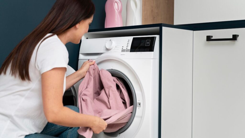 Mujer sacando ropa de la lavadora