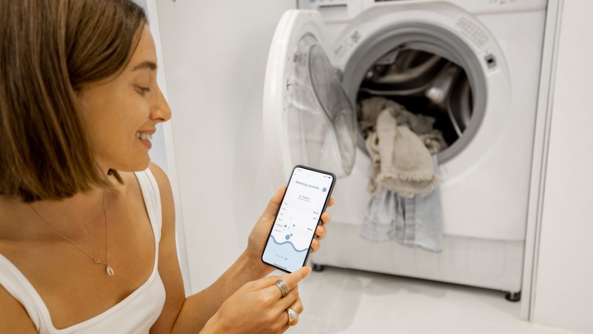 Mujer controla lavadora con celular