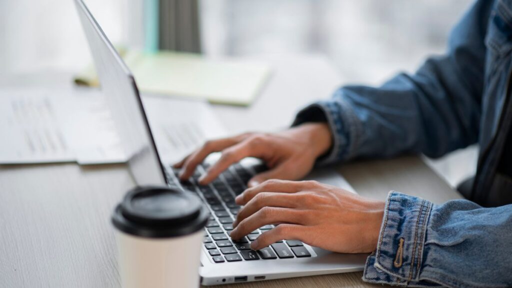 Persona escribiendo en teclado de computadora