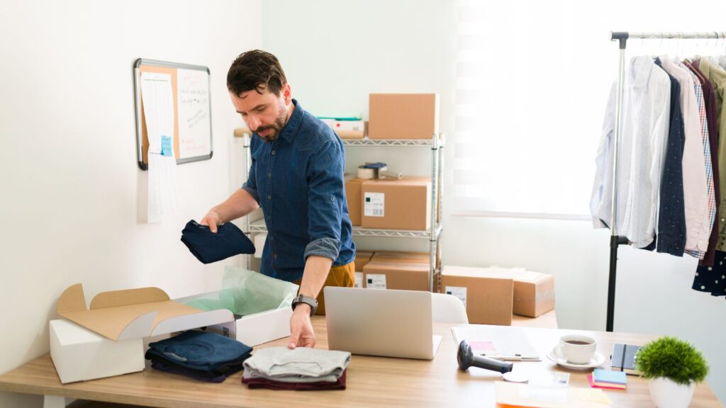 Hombre empaquetando envíos de su tienda de ropa online