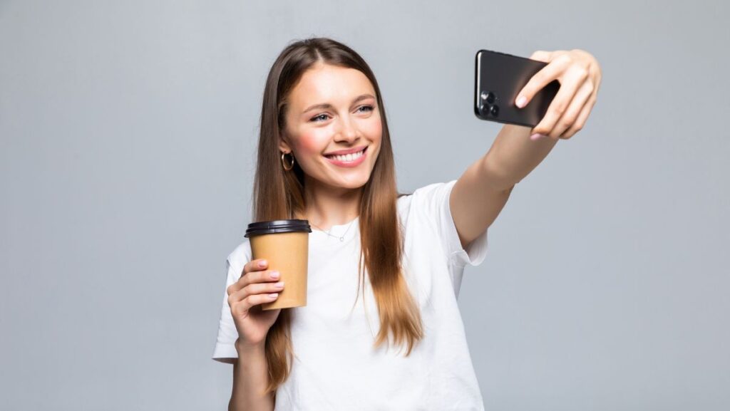 Joven tomándose foto selfie con café