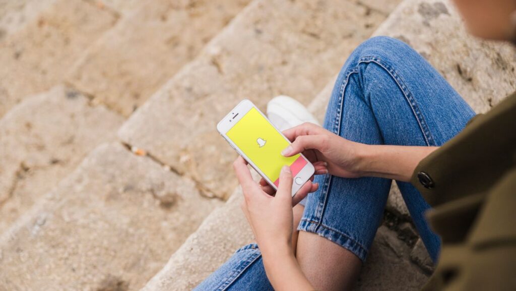 Joven usando Snapchat en su smartphone