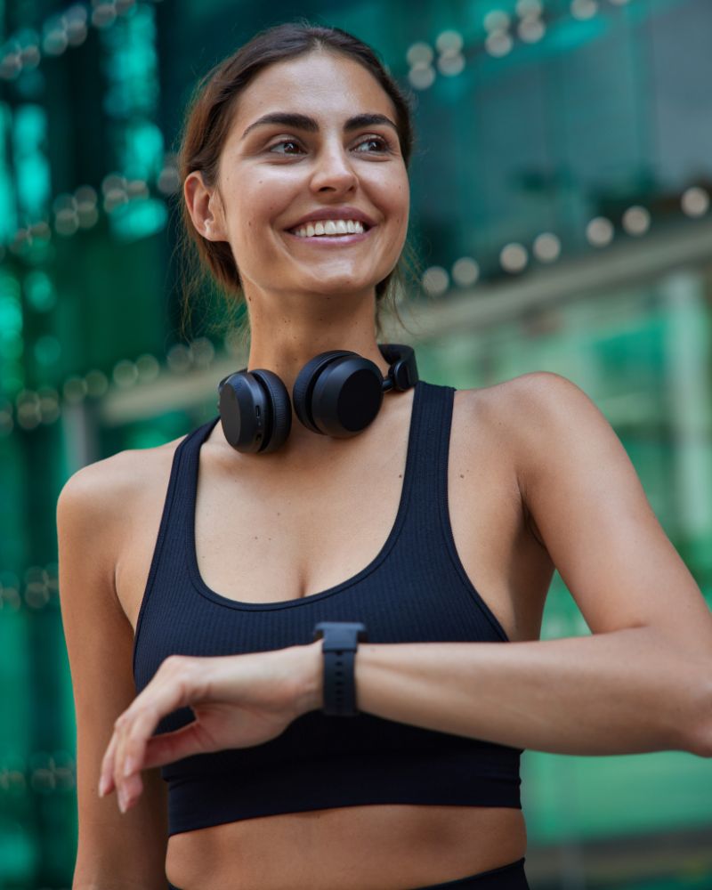 Mujer haciendo deporte con audífonos y pulsera inteligente