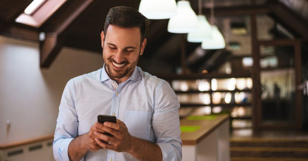 Hombre sonriendo con celular