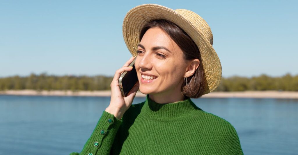 Mujer usando smartphone con sombrero