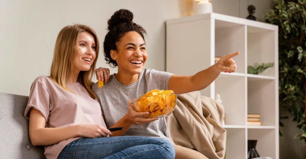 Mujeres comiendo papas mientras ven televisión