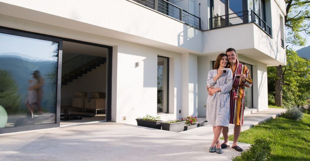 Pareja frente a casa tras comprar vivienda