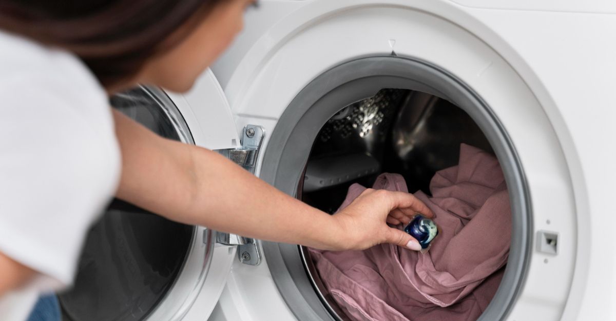 Mujer colocando ropa en lavadora