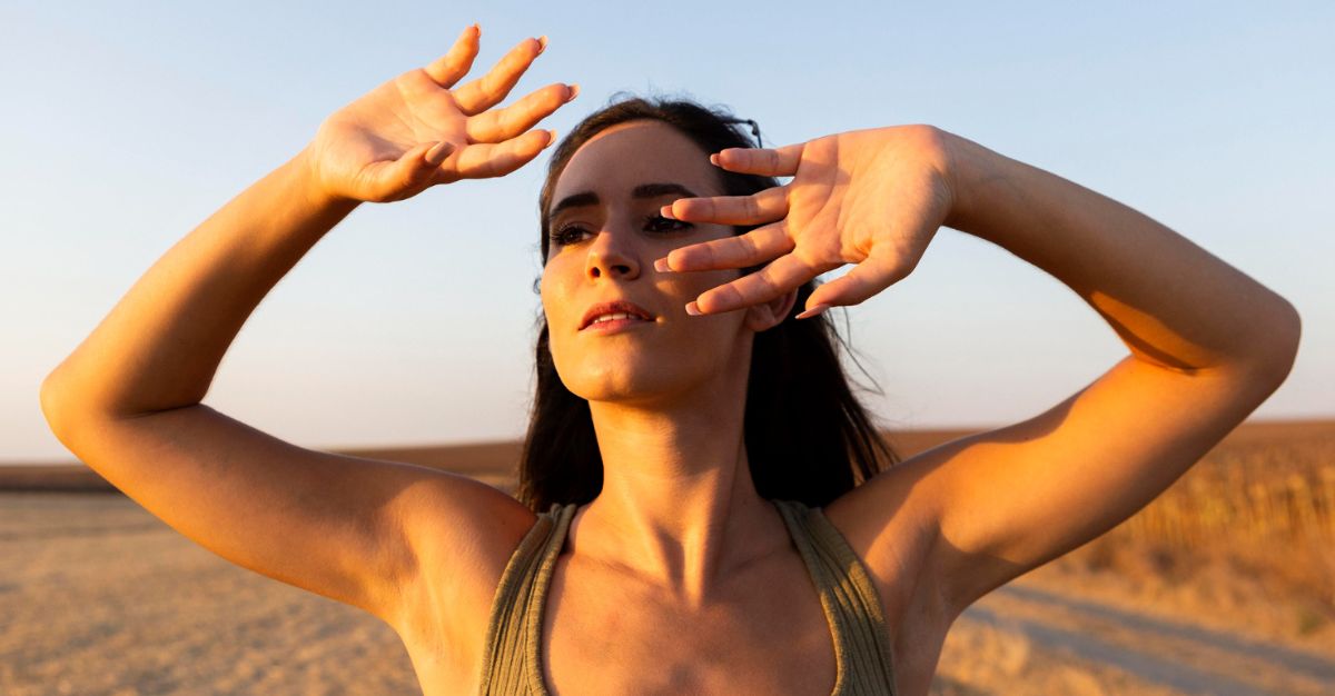 Mujer tapando rayos del sol en el rostro