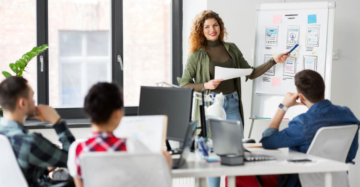 Mujer hablando frente a empleados en formación continua