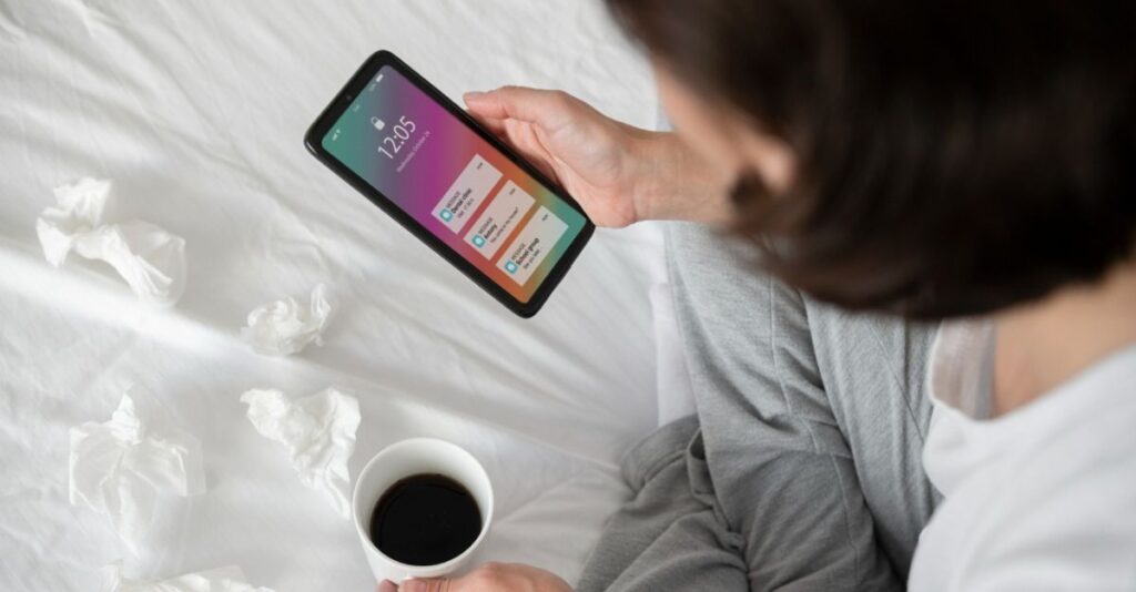 Mujer con taza de café y celular