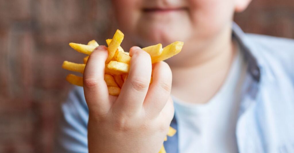 Niño comiendo papas fritas